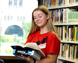Student in library holding books